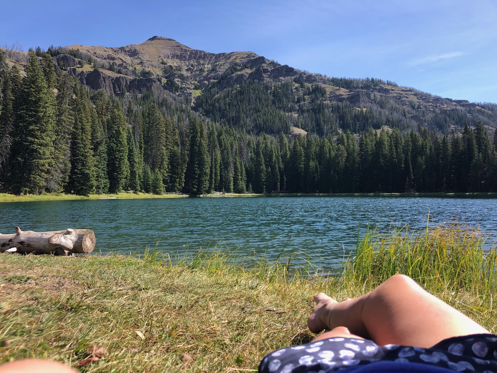 A backpacking confession: An alpine lake with Maggie's tired hiking feet in the shot.