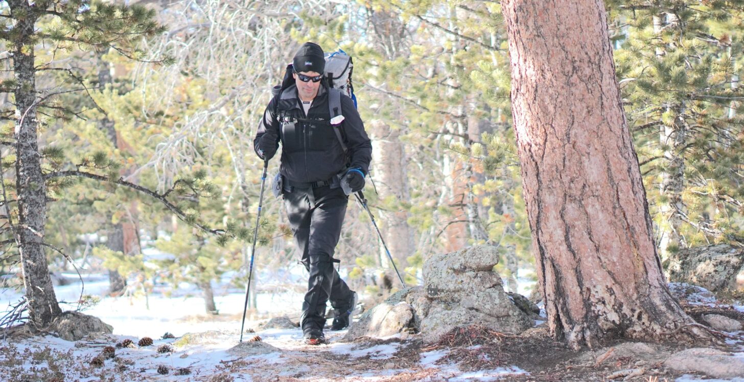 man backpacking on a winter trail