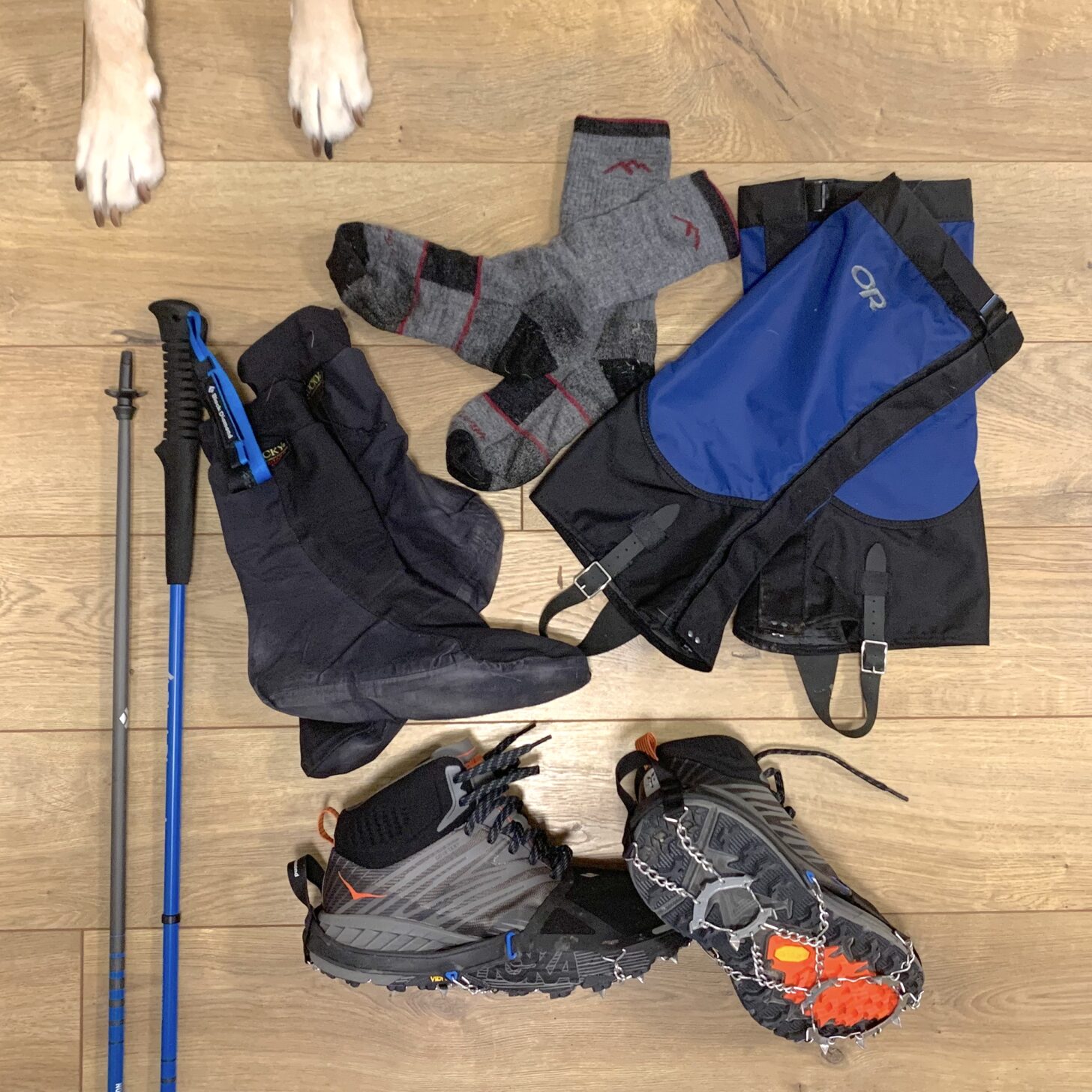 layout of trekking poles, waterproof socks, wool socks, gaiters, shoes, and traction spikes