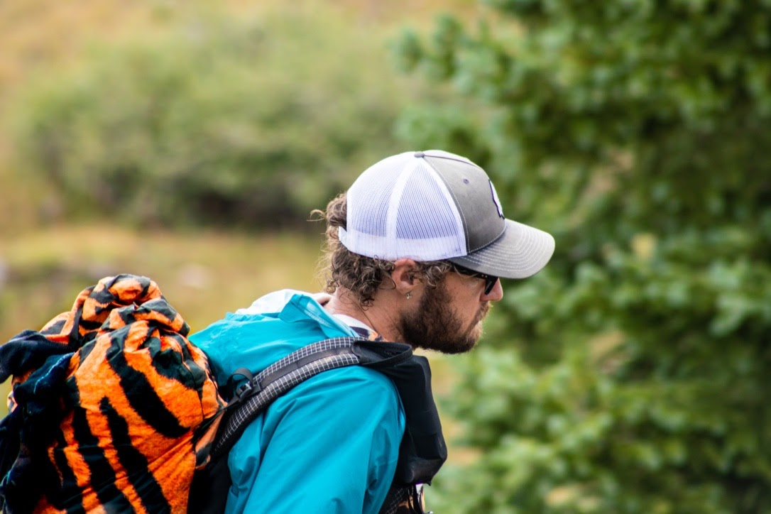 a man hiking with a tiger-striped backpack