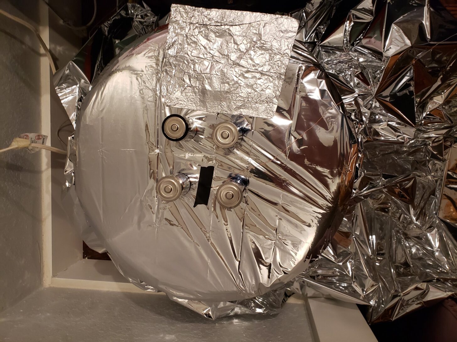 A space blanket stretched over a device for measuring heat reflectivity.