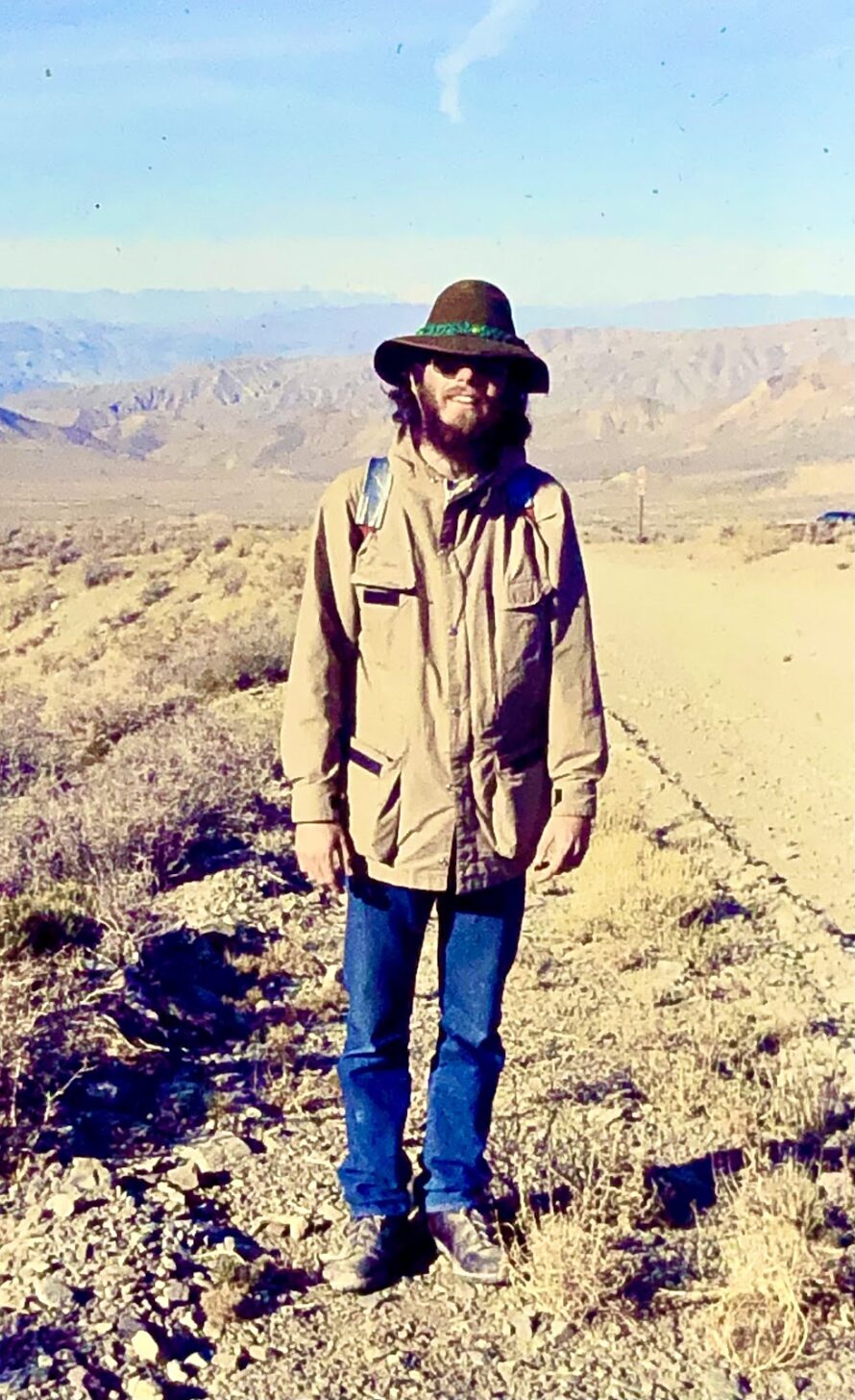 a man standing in death valley with a brown coat