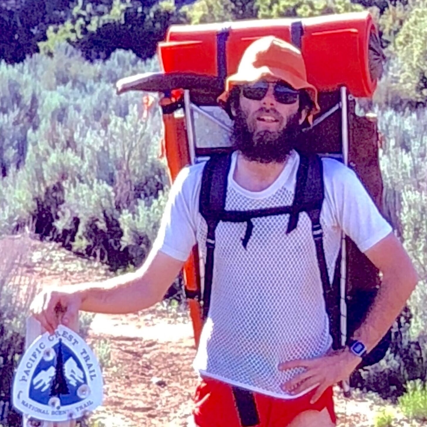 a bearded man wearing a white mesh shirt