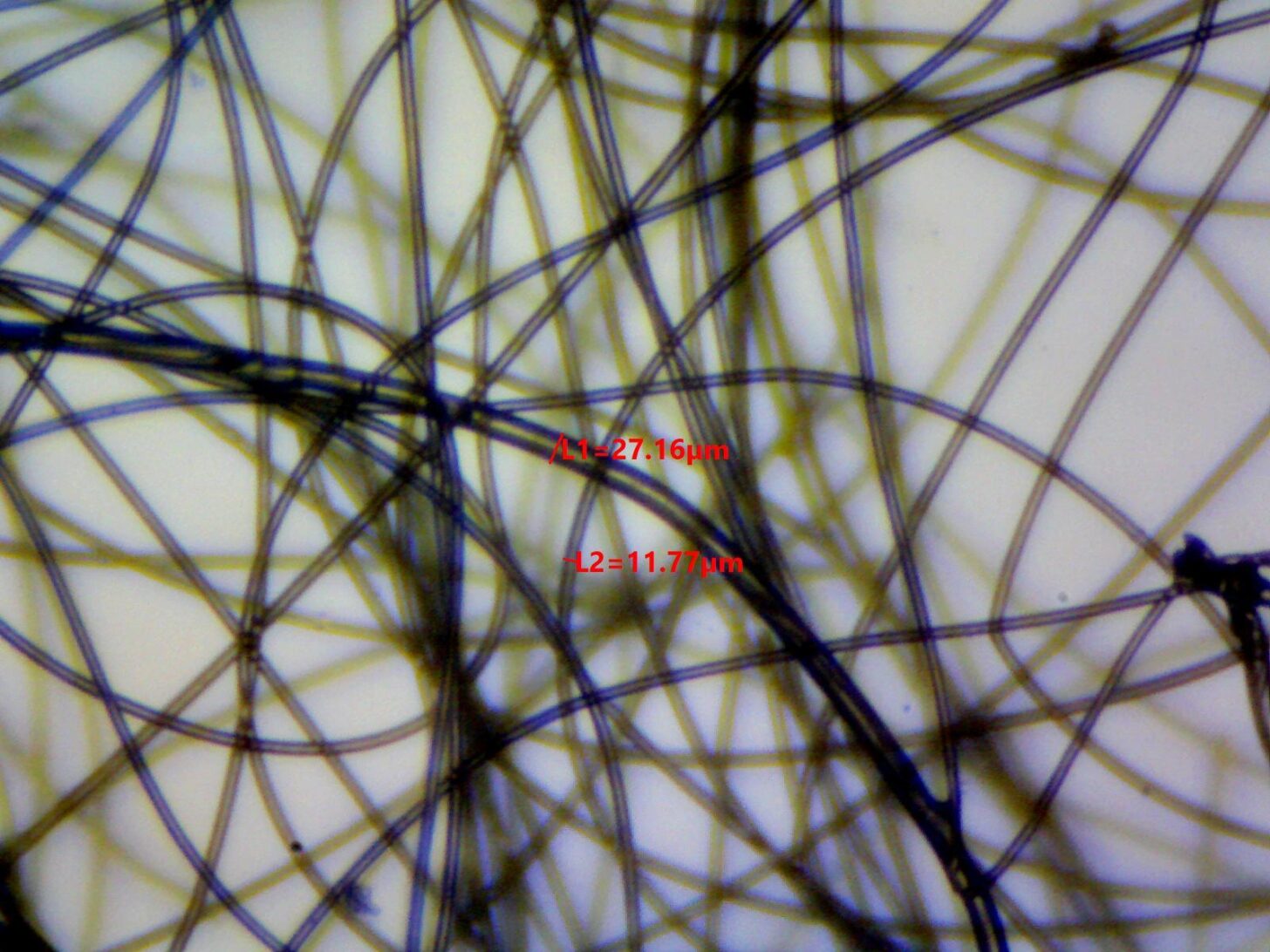 Silicone Bonded Fiberfill photomicrograph showing fiber diameter measurements of 14.00, 26.82, and 43.87 microns.
