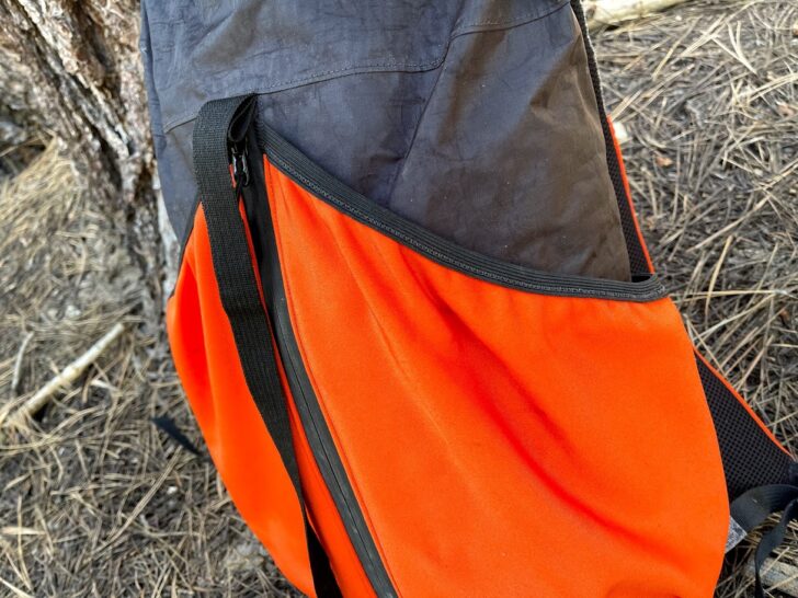 a medium shot showing the orange rear pockets cut at a sharp angle and angling down towards the sides of the pack.