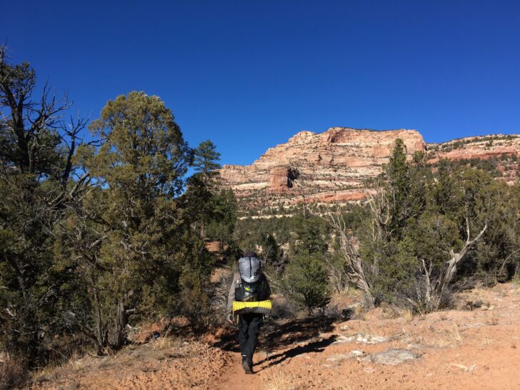 a man backpacks through the Utah desert