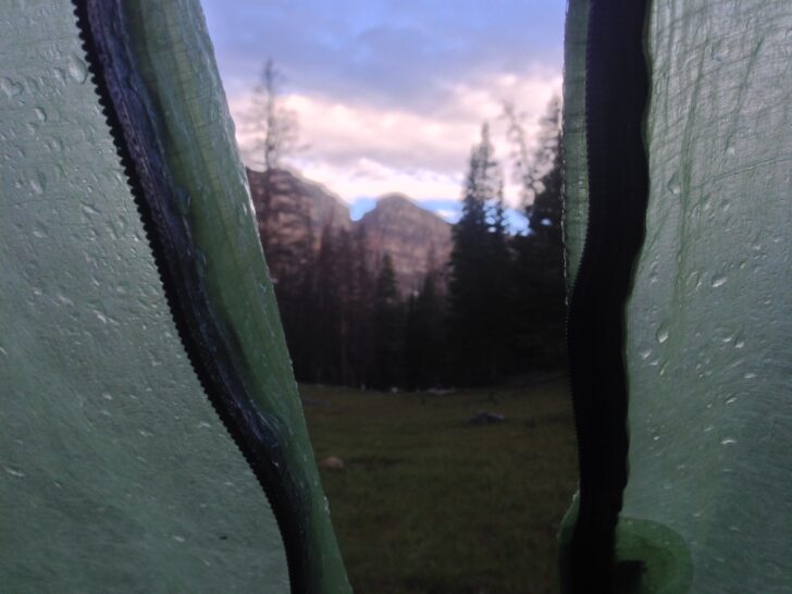 a view of mountains at sunrise from within a tent