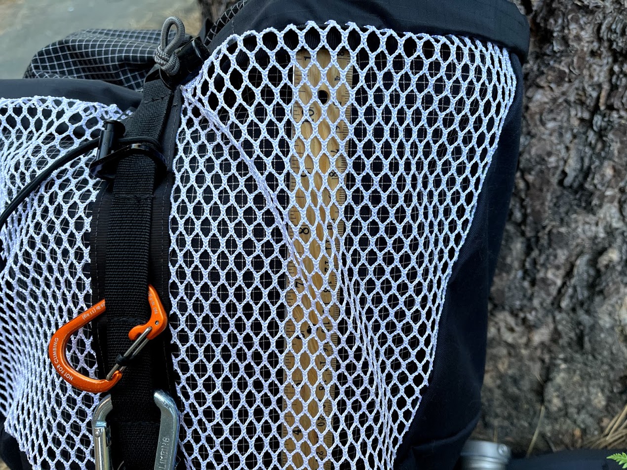 A close up of the open mesh pocket and a line of diasy chains with caribener clips.