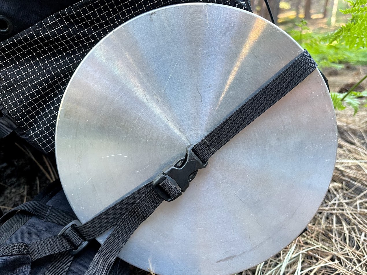 A close up of some nylon webbing running diagonally across the end of the bear canister.