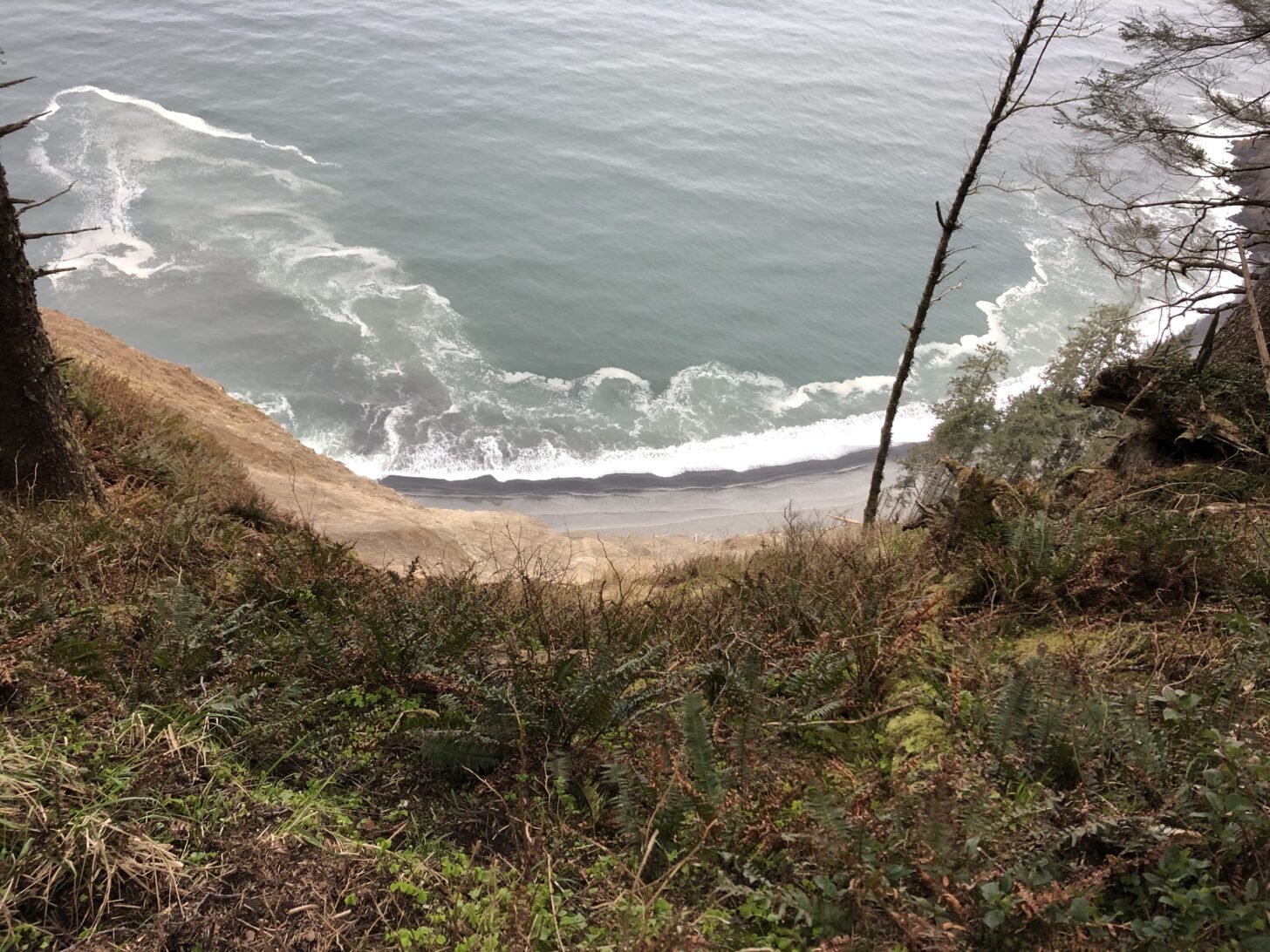 a view of a beach from high up on some cliffs above the water