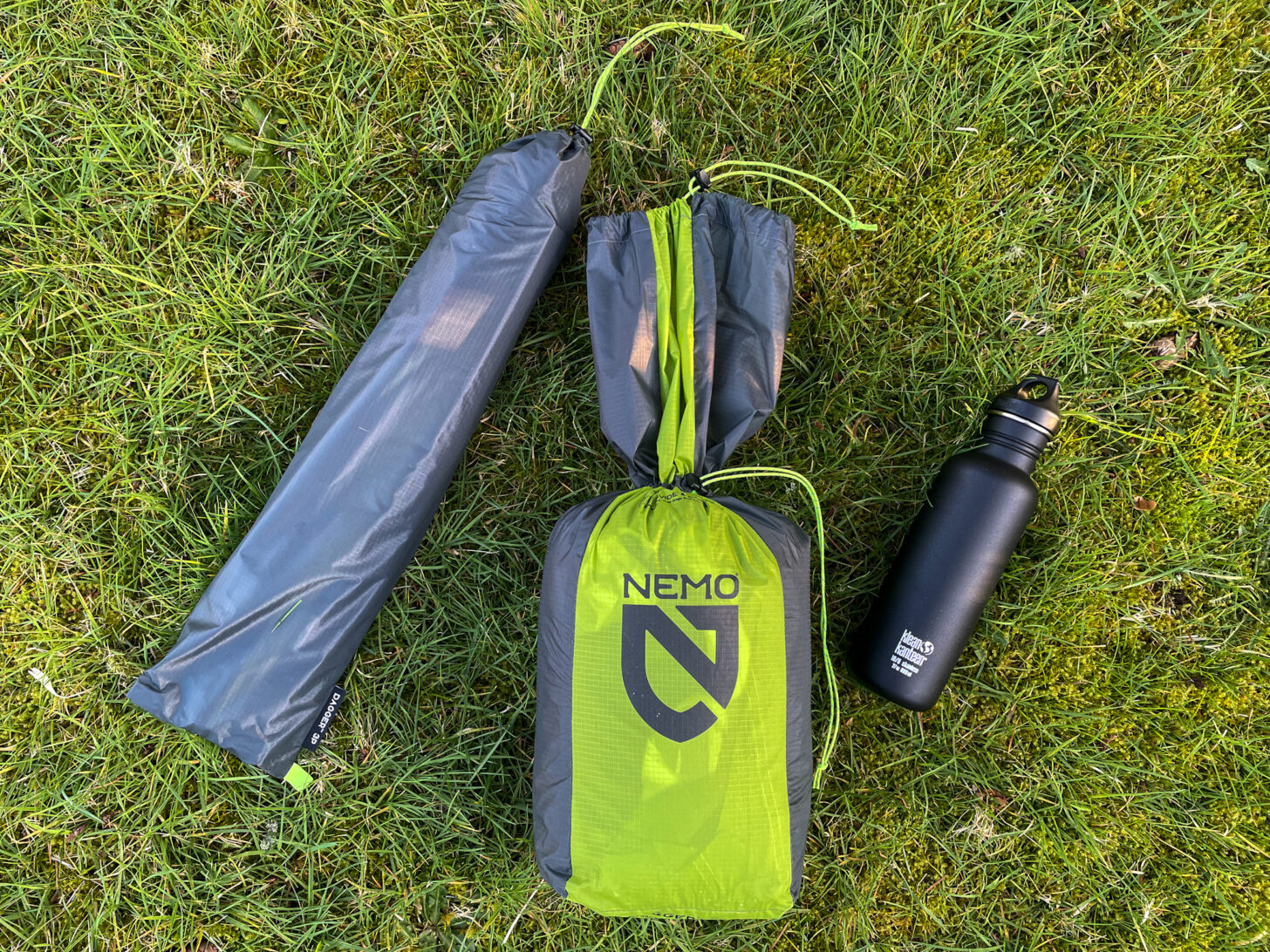 Stuff sack, water bottle, and tent poles divided out on the ground.