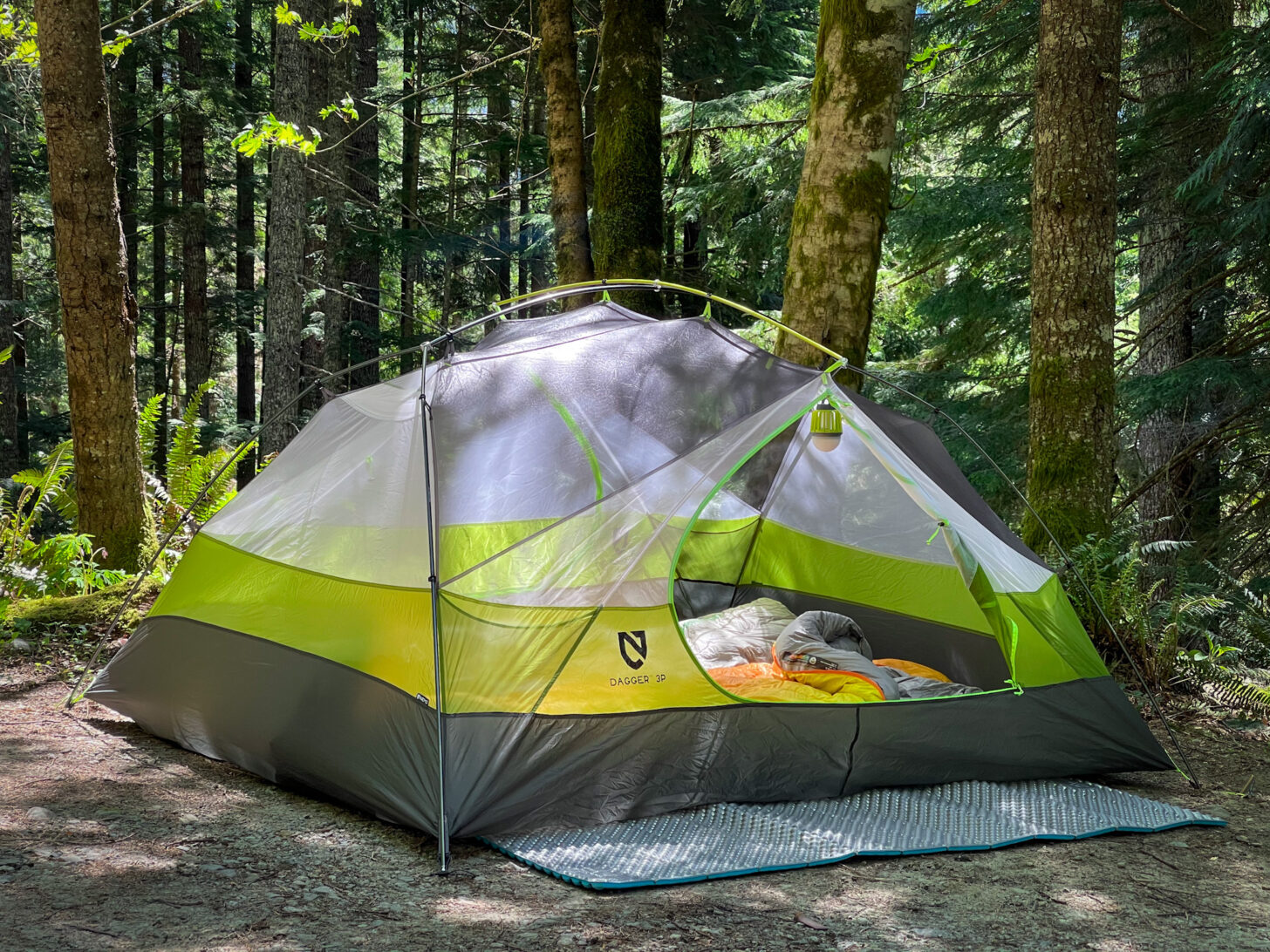 A wide shot of the shelter set up in a lush forest.