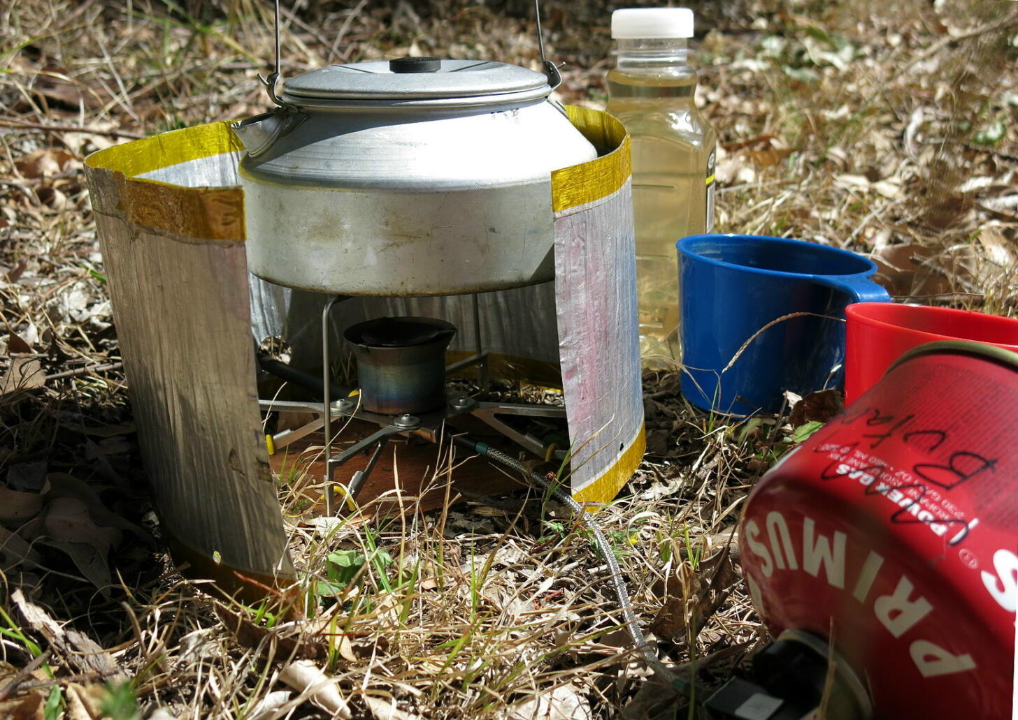 A remote inverted canister stove heats water in a pot.
