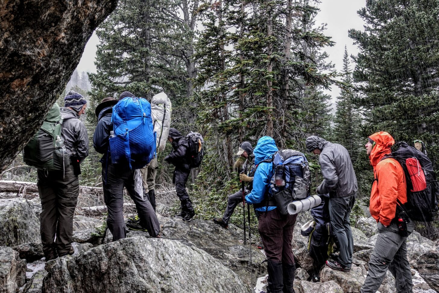 group of hikers in a sleet storm hiking through the forest