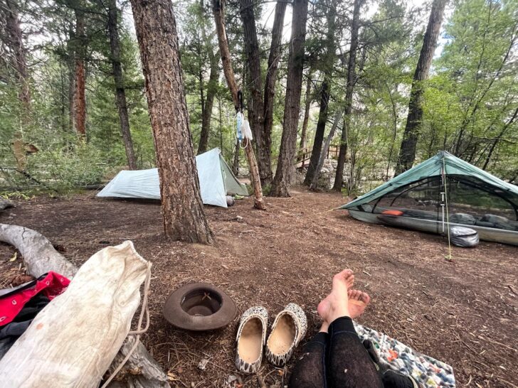a campsite with two shelters and the authors feet in frame