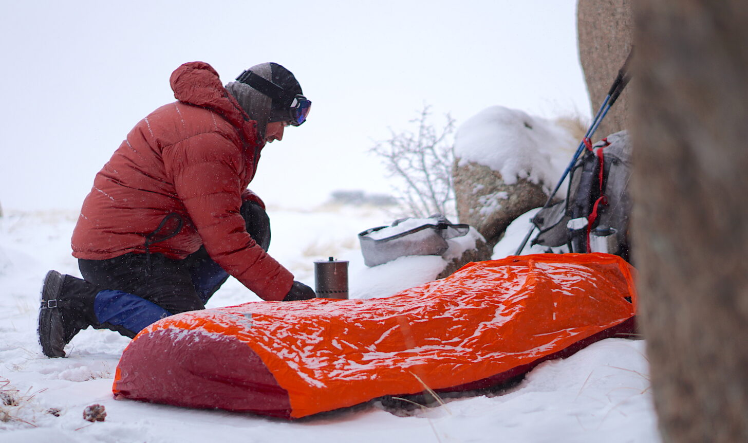 hiker making a pot of soup in snowy weather