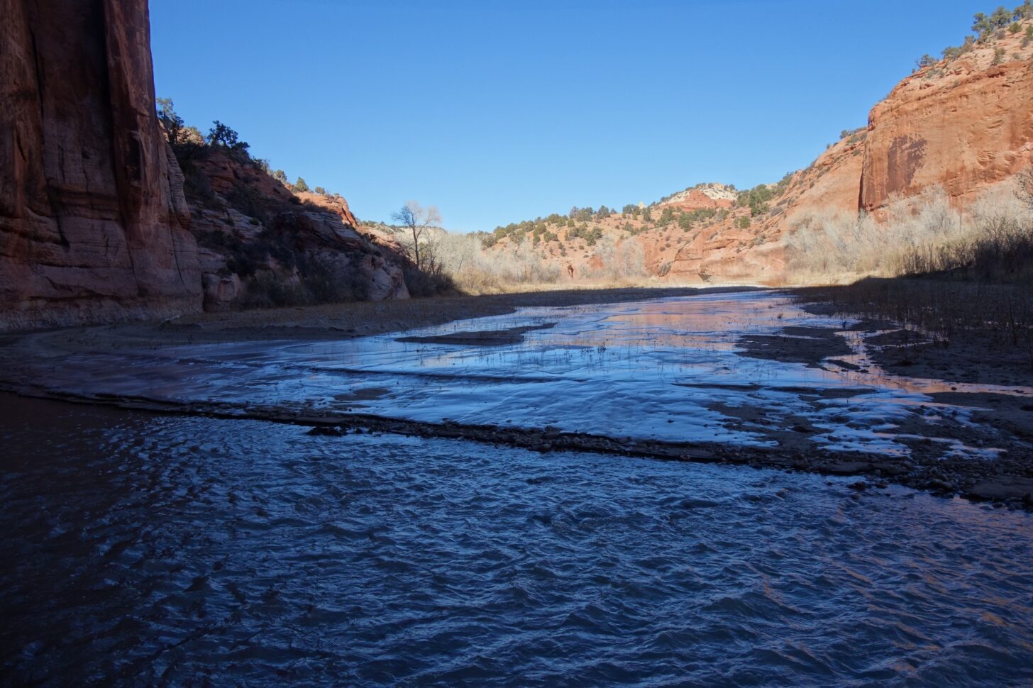 a frozen river in a desert canyon