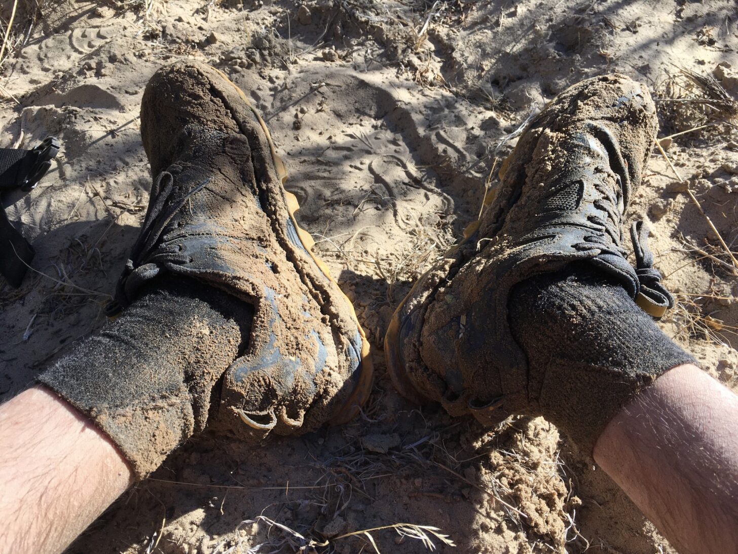 a man's mud-covered socks and shoes