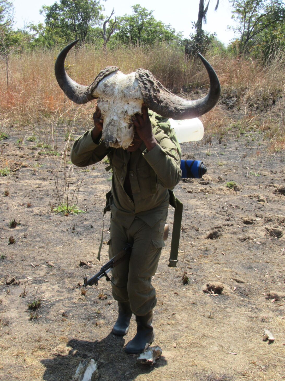 a man holding the head of a buffalo in front of his own head