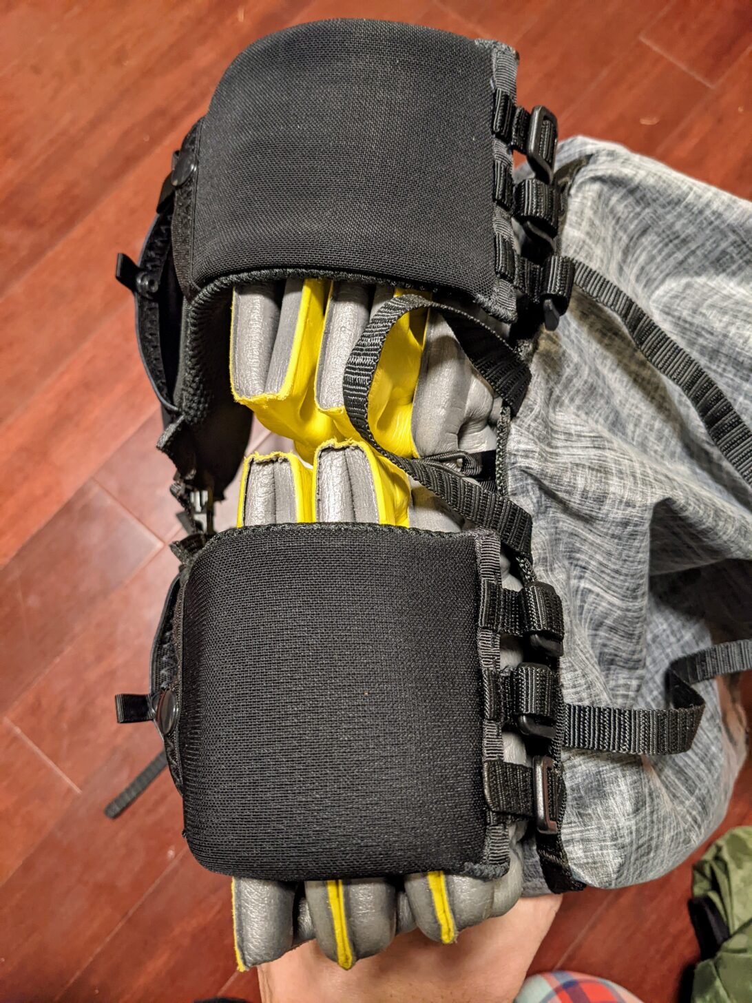 a shot from above looking down at the top of the Nashville Pack Cutaway backpack. The shoulder straps are resting on top of a pad which is folded and sitting against the back panel of the pack.