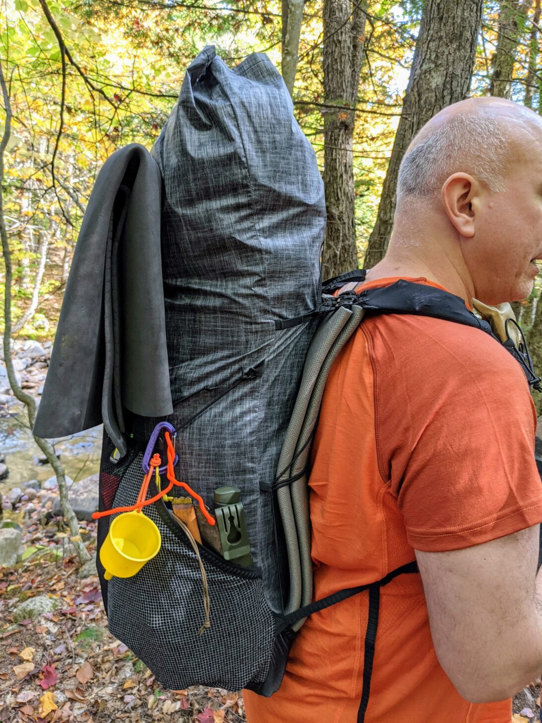 a side view of a man wearing a Nashville Pack Cutaway backpack.