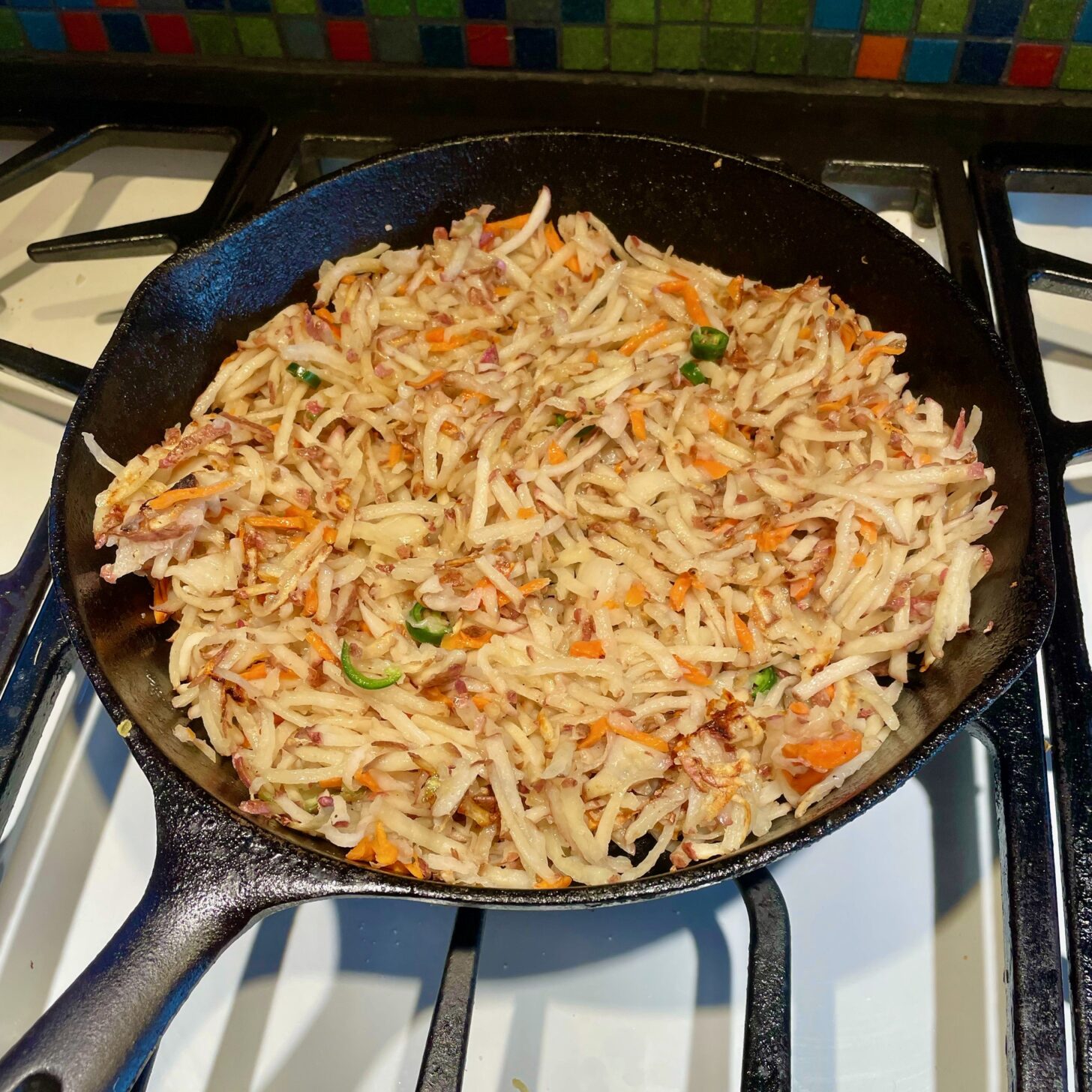 hash browns being cooked in a cast iron skillet