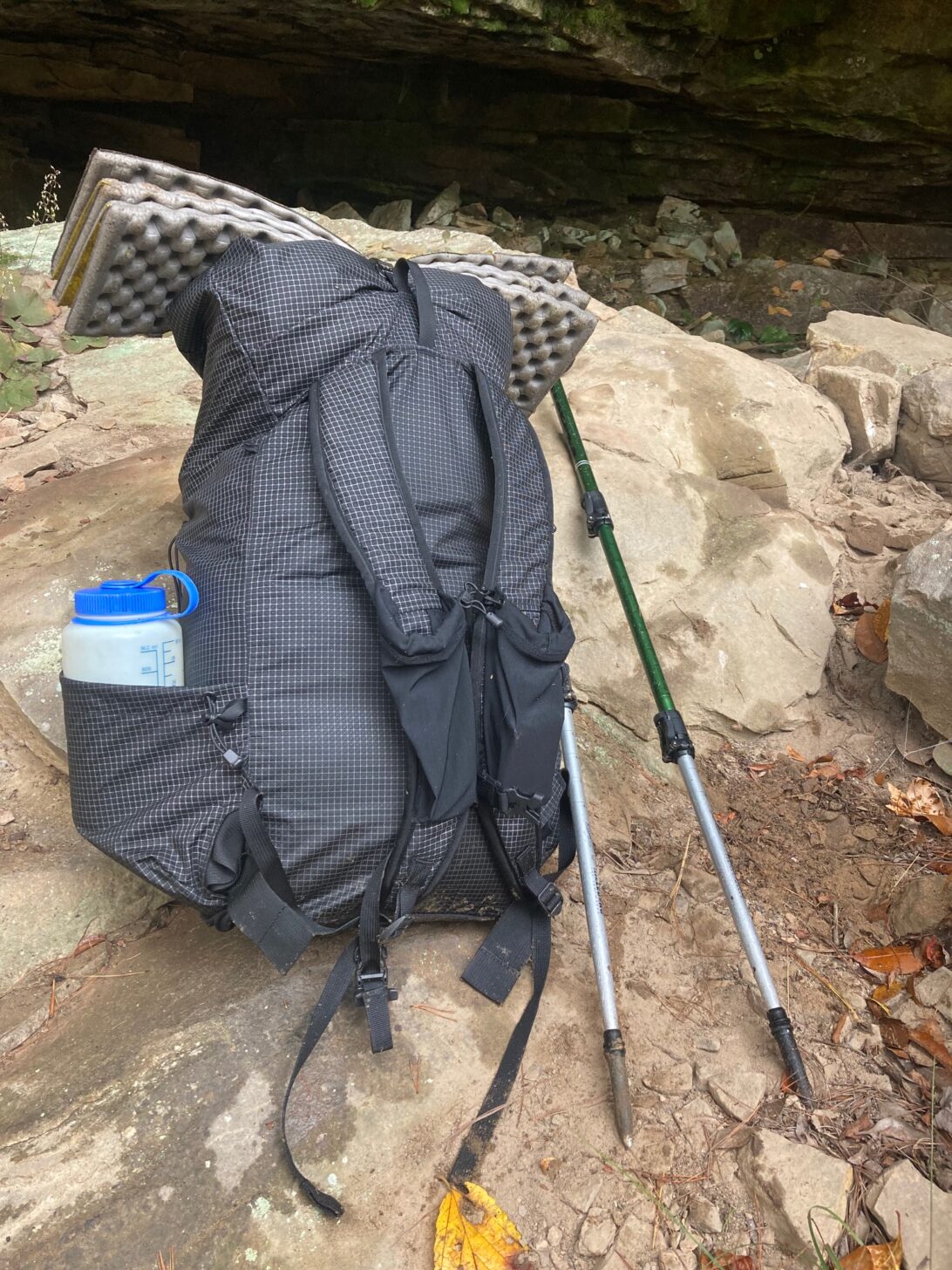 A backpack sits in front of rocks.