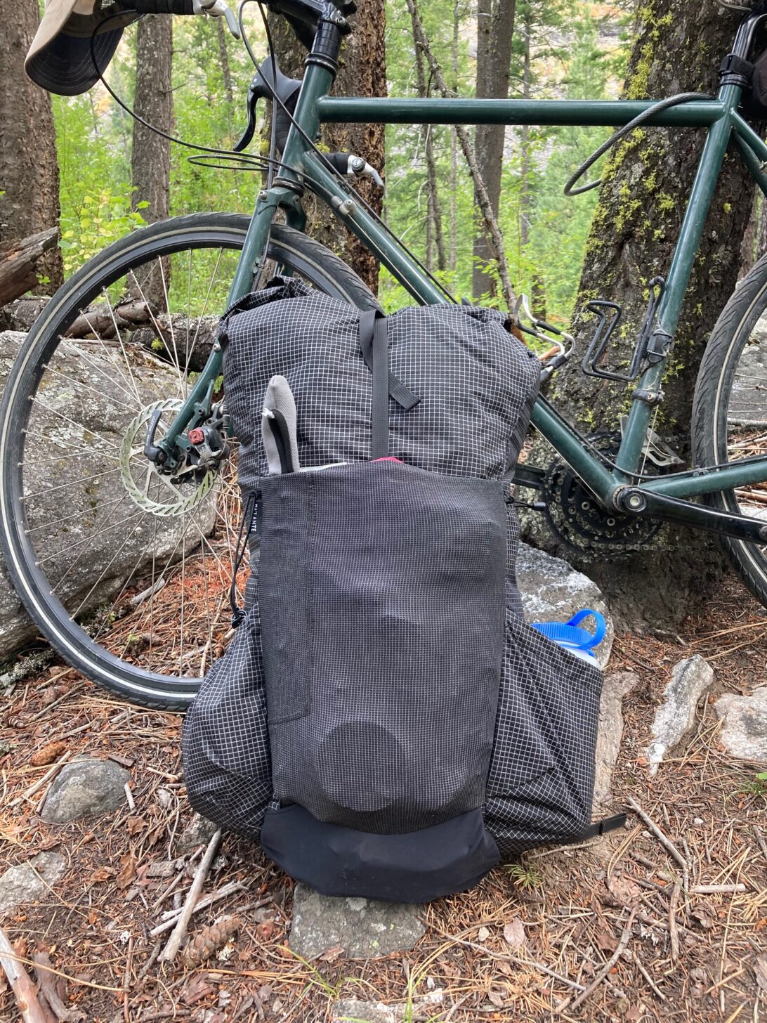 A backpack is in front of a bicycle.