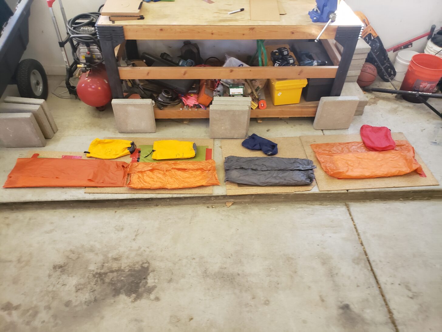 a garage workshop with insulation samples inside stuff sacks and with paving stones for crushing nearby.
