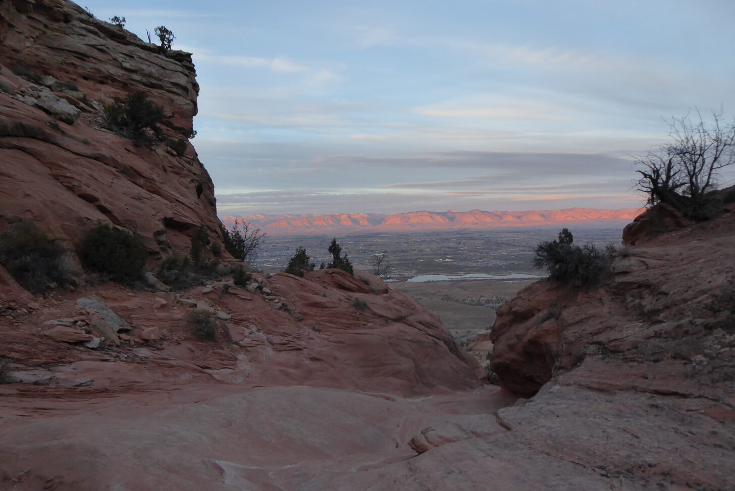 a view looking down the valley, with rosy cliffs in the background