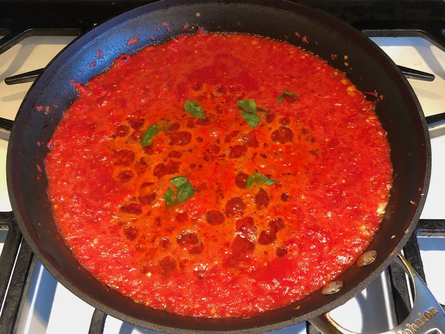 finished sauce in a pan topped with basil
