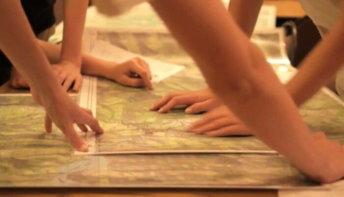 a close-up of hands pointing to maps