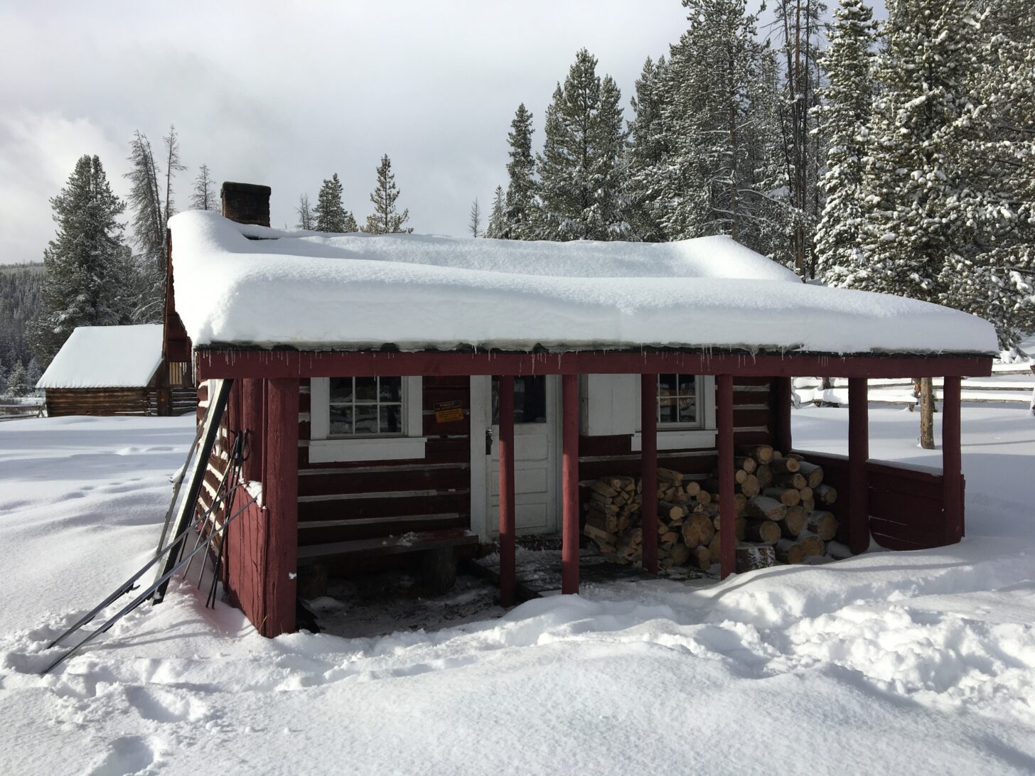 A cabin is pictured in a snowy landscape.