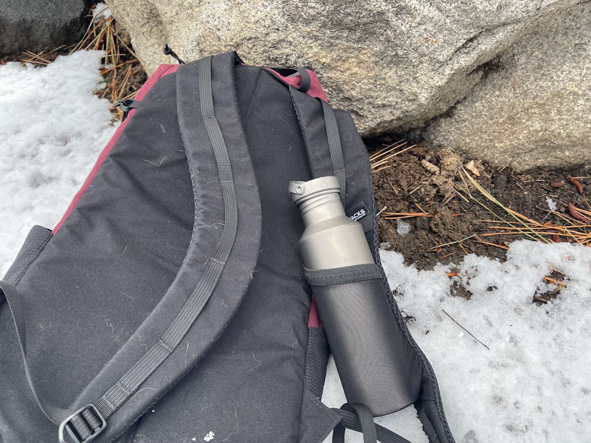 A medium shot of a water bottle in a shoulder strap pocket.