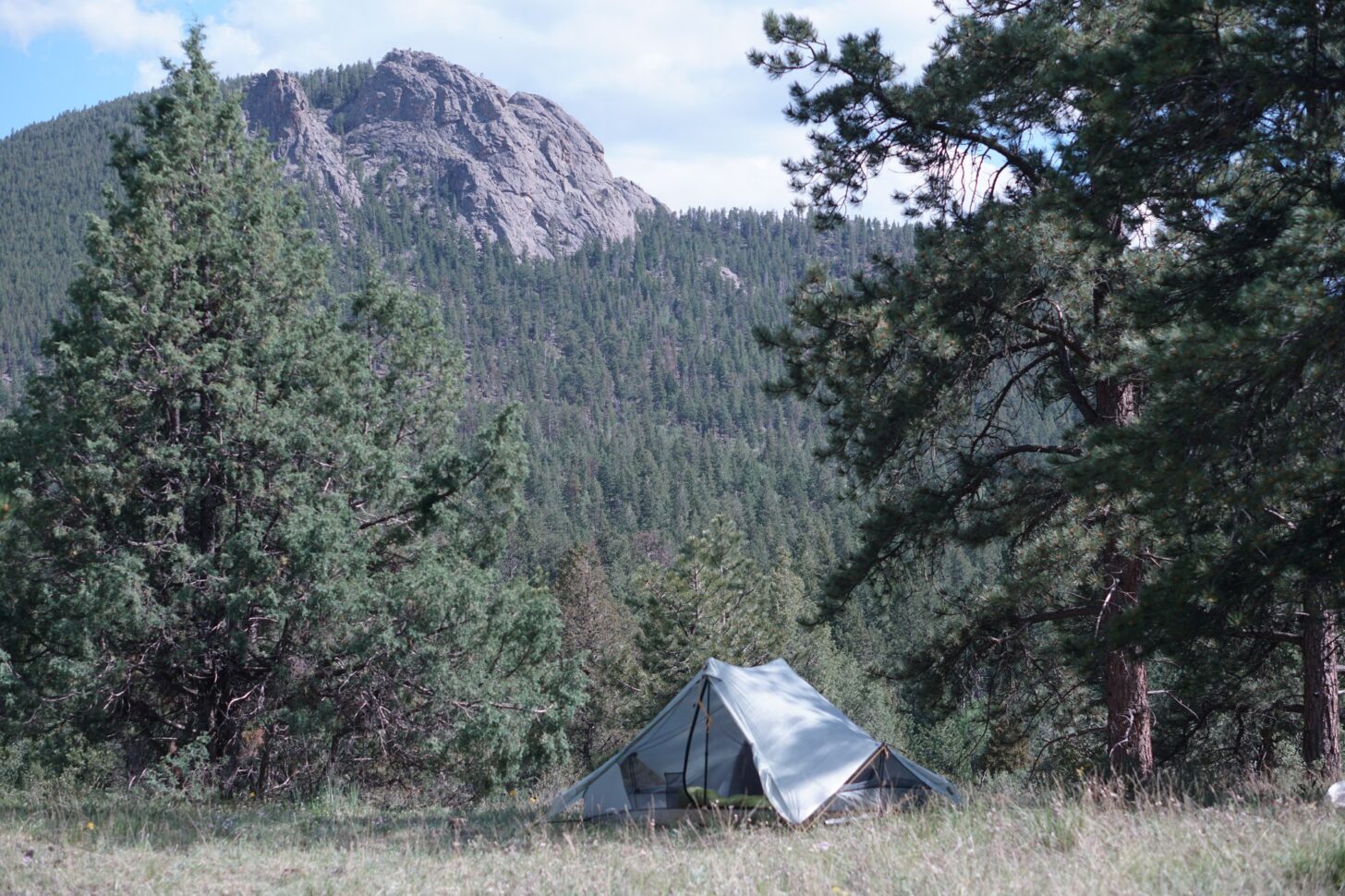 a Tarptent Dipole small in the frame with a mountain overhead.