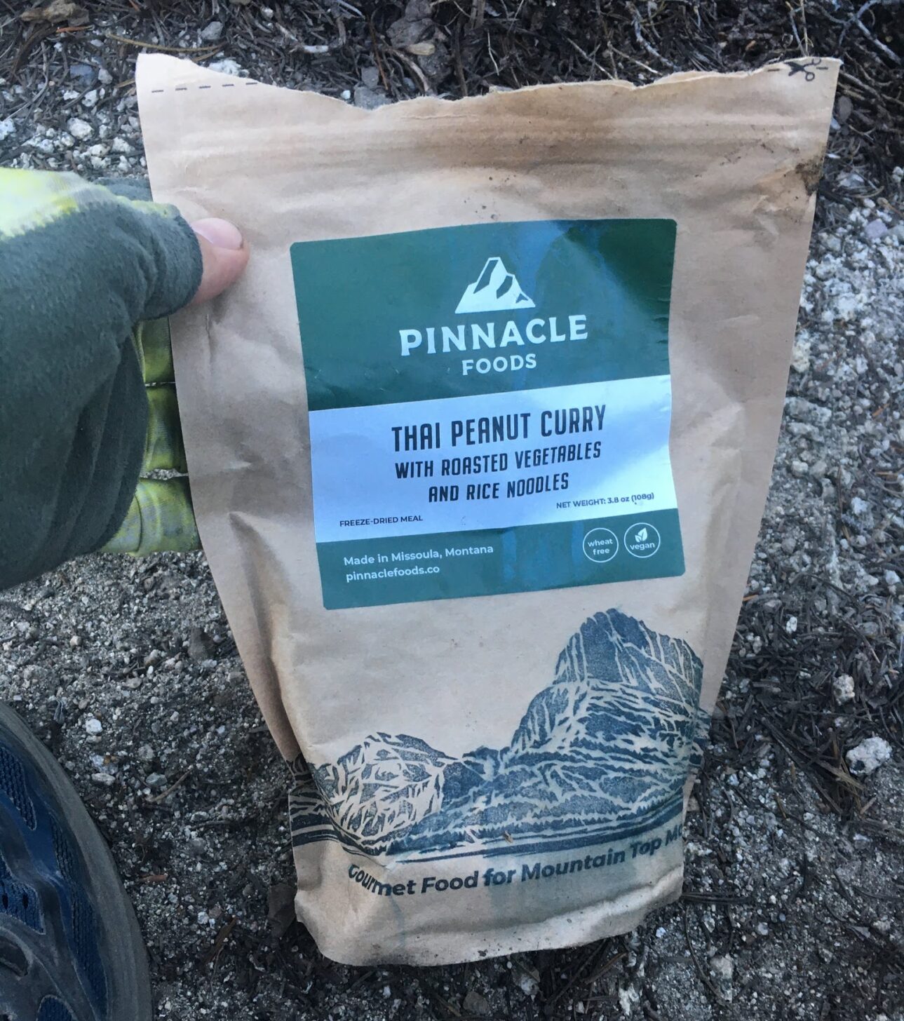 a hand holds a bag of packaged backpacking food