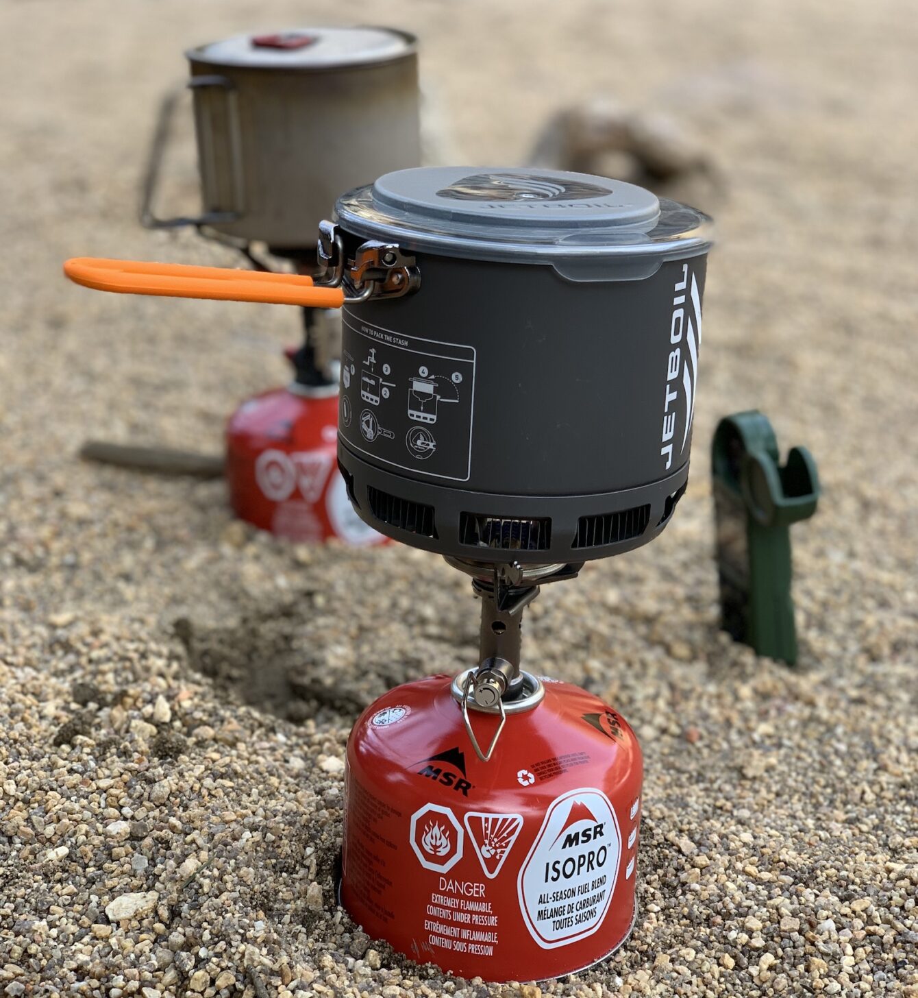 an upright canister stove attached to a fuel canister