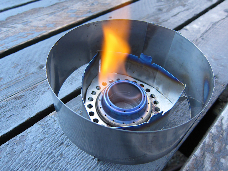 a photo of a lit alcohol stove with orange flames