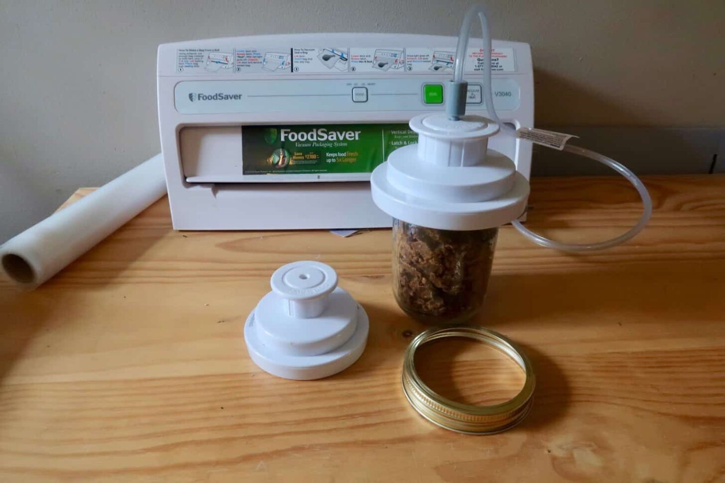 A vacuum sealer attached to a mason jar of dehydrated food.