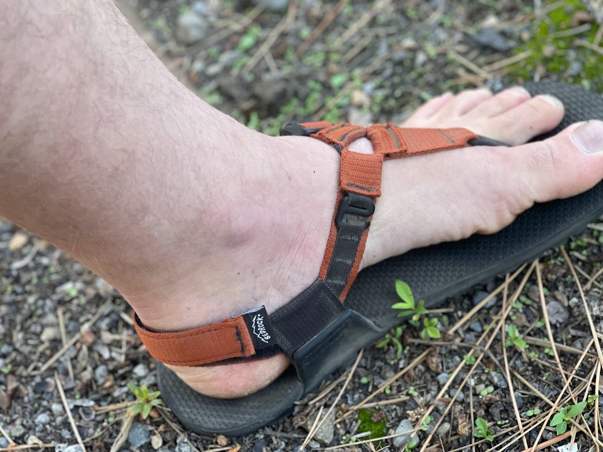 a medium shot of a man's pale, pale foot wearing the bedrock sandals.