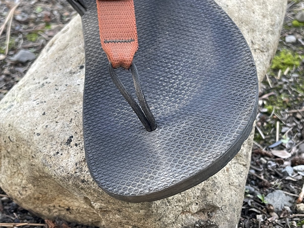 A close-up of the nylon toe thong coming out of the front of the sandal.