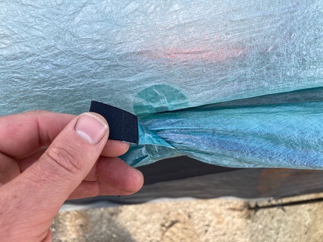 person operating a magnetic vestibule door closure on a tent