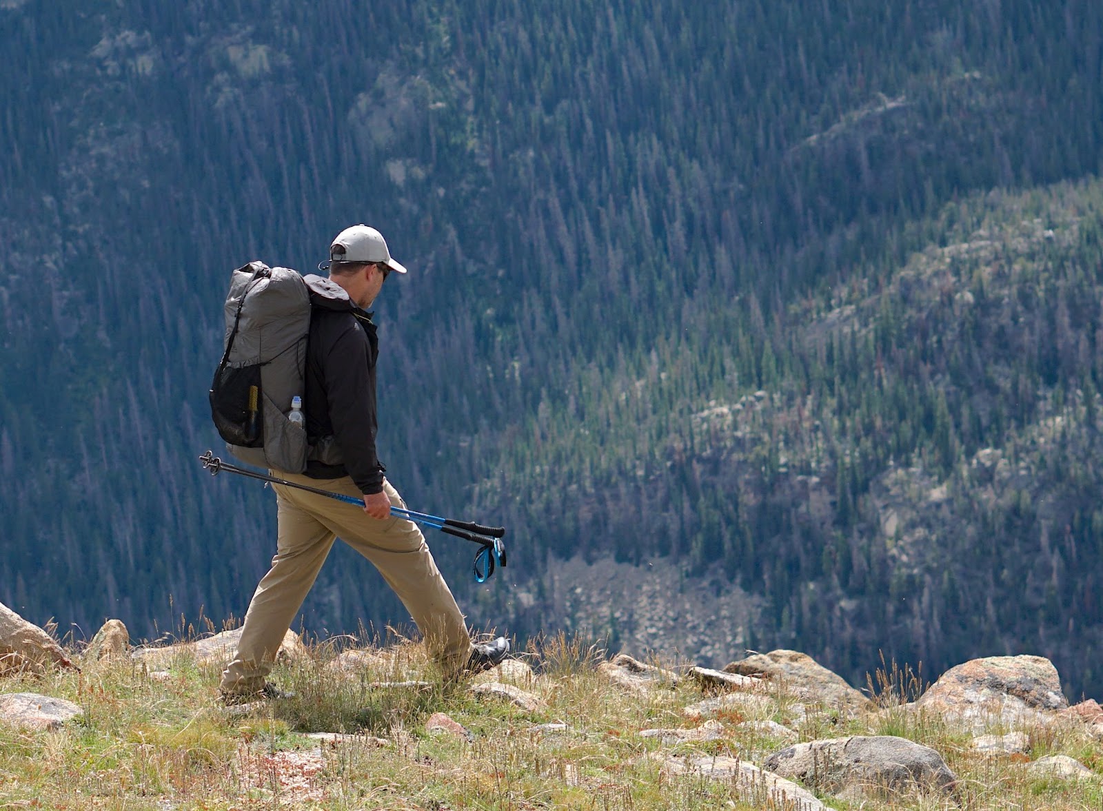 a man walks along a ridge wearing a Durston Kakwa 40 backpack