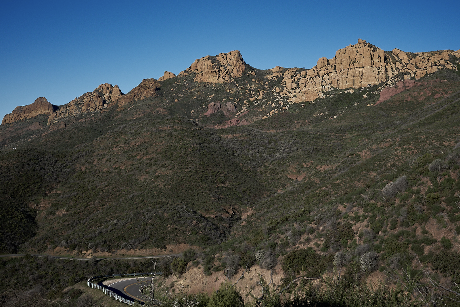 a winding road in the middle of a mountain range