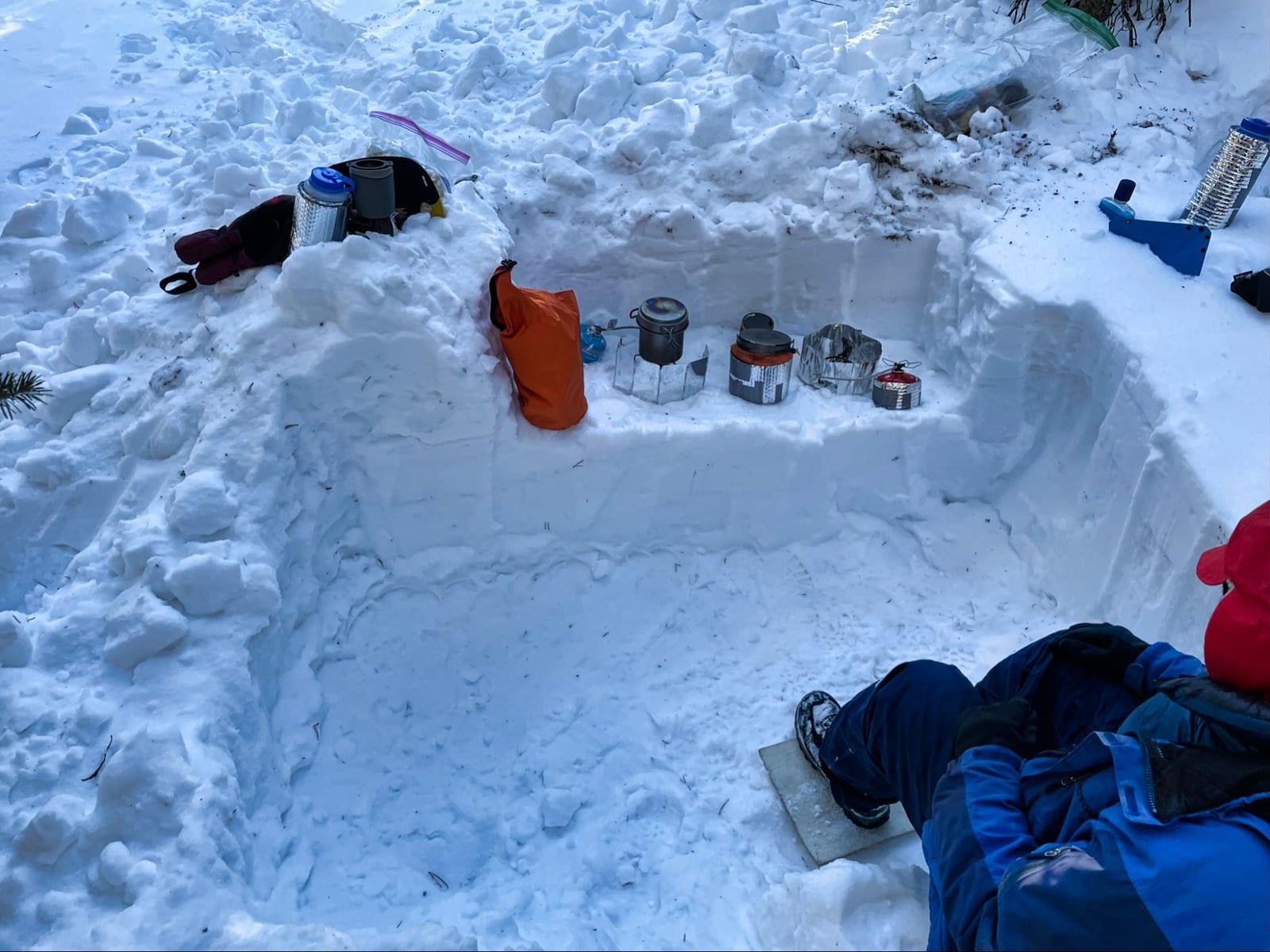 a man sitting in the middle of a deep snow pit