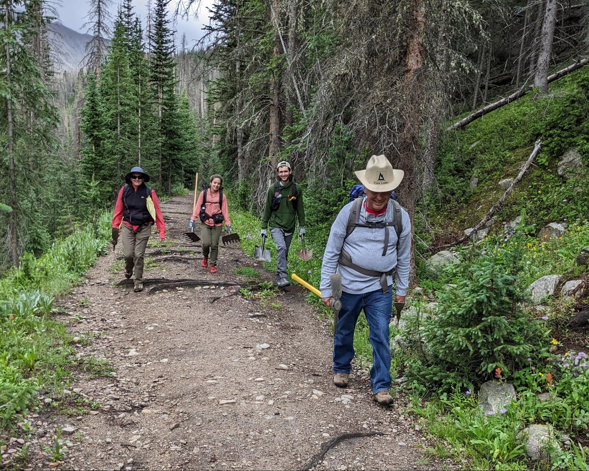 a group of people walking down a dirt road