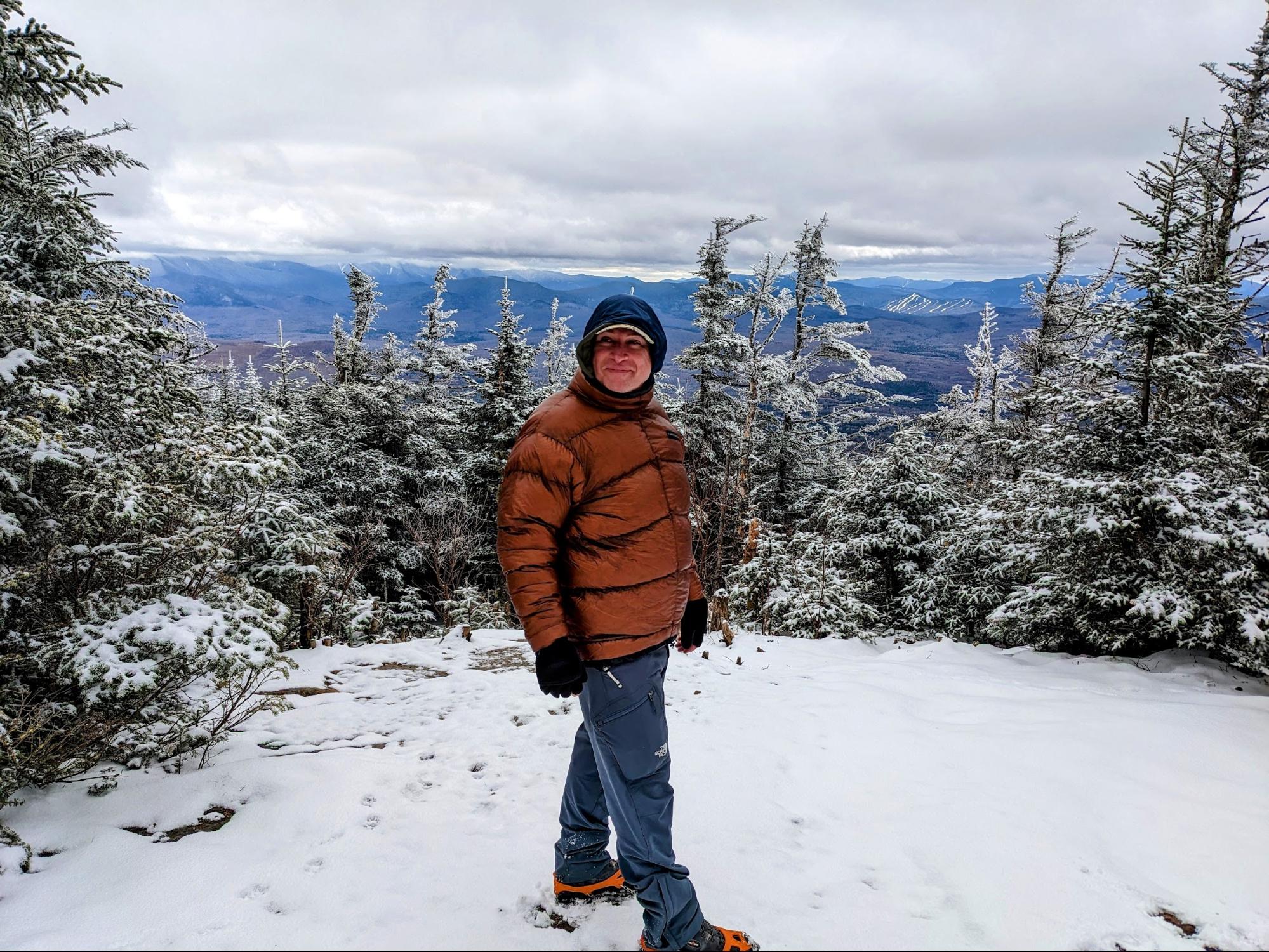 a man standing on top of a snow covered slope