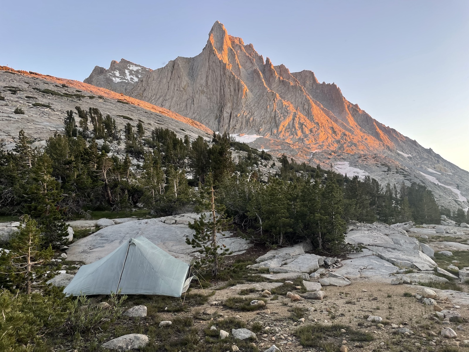 a tent pitched up on a rocky hillside