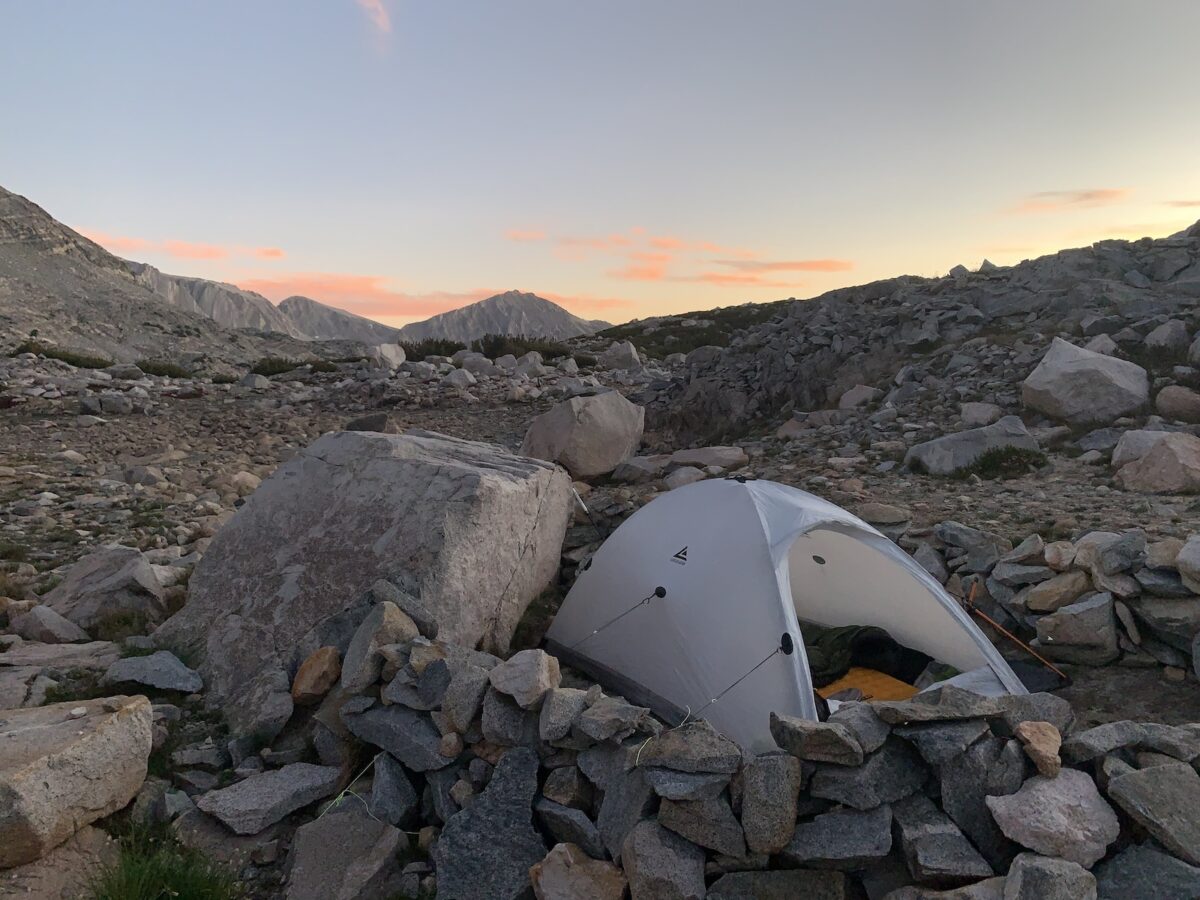 a white tent sitting on top of a pile of rocks