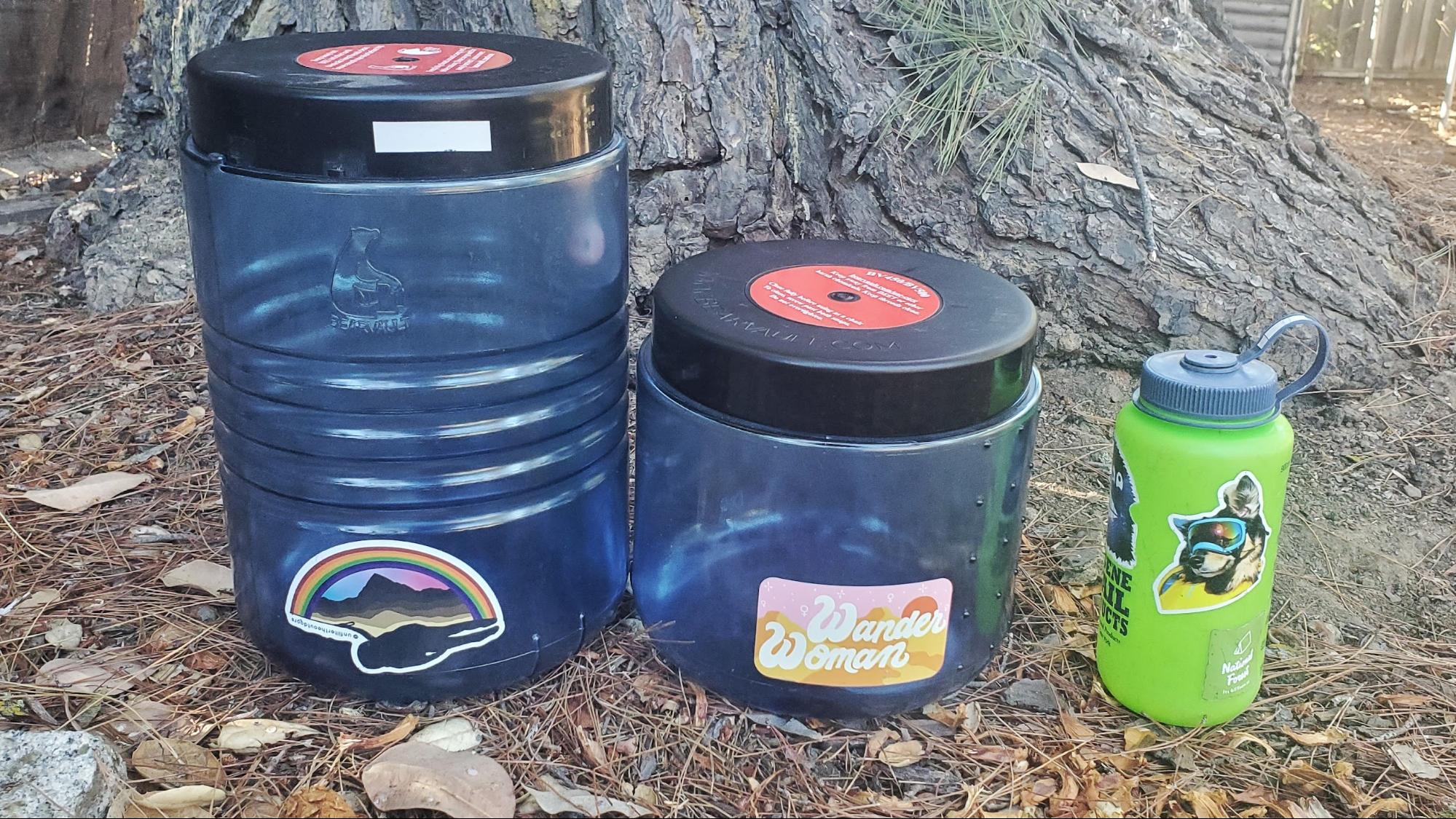 a couple of water bottles sitting next to a tree